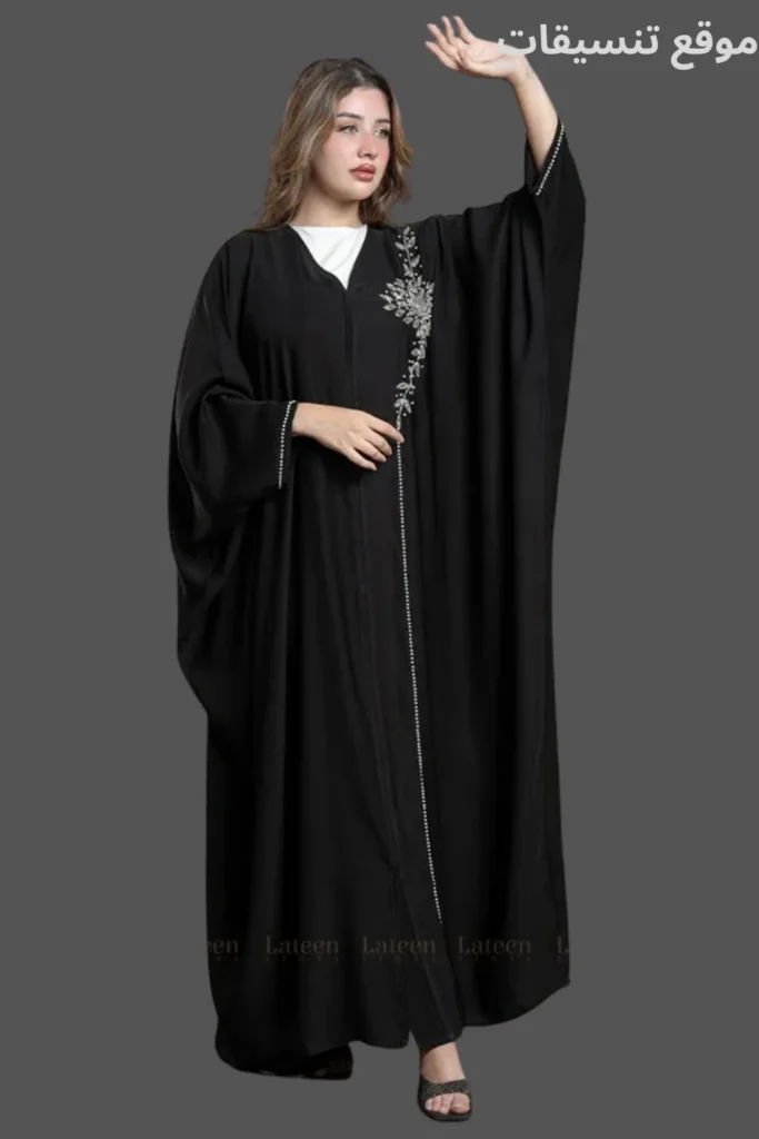 عباية بشت سوداء تتميز بتطريز ورد فضي ناعم على جانب واحد وأكمام واسعة محددة.