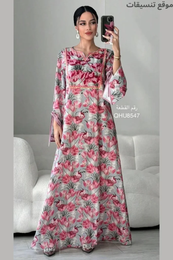 جلابية من قماش حريري ناعم بلون رمادي مزرق، مطبوعة بالكامل بزهور التوليب الوردية والحمراء، ياقة مطرزة بتطريز ناعم، أكمام واسعة.